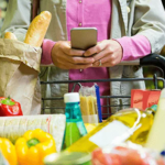 Woman-using-mobile-phone-while-shopping
